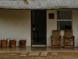 two chairs sitting in front of a house at Butjani Lodge in Cullinan