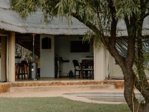 a porch of a house with chairs and a table at Butjani Lodge in Cullinan