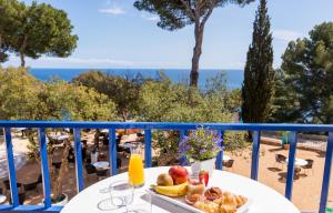Ein Tisch mit Obst auf einem Balkon mit Meerblick in der Unterkunft Hotel Sant Roc in Calella de Palafrugell