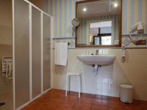 a bathroom with a sink and a mirror and a stool at Hospedium Hotel Rural Ruta Imperial H-CC-00660 in Jarandilla de la Vera +34 photos