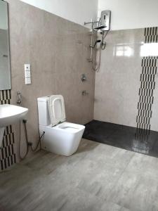 a bathroom with a toilet and a sink at Peacock Forest Villa in Kosgoda