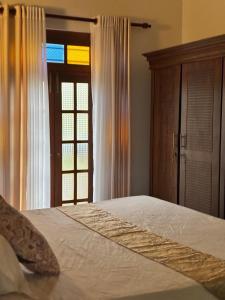a bedroom with a bed and a window and a door at Peacock Forest Villa in Kosgoda