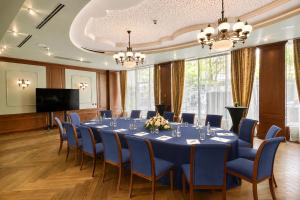 a conference room with a long table and blue chairs at Crystal Palace Boutique Hotel in Sofia