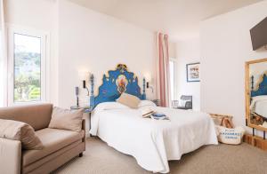 ein Schlafzimmer mit einem Kingsize-Bett und einer Couch in der Unterkunft Hotel Sant Roc in Calella de Palafrugell
