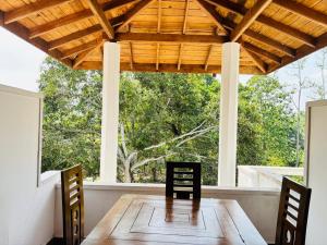 a dining room with a wooden table and chairs at Peacock Forest Villa in Kosgoda