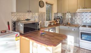 a kitchen with a counter top with a microwave at Bonnie Brae Cottage in Hepburn Springs +9 photos