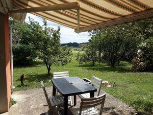 a black table and chairs under a wooden umbrella at Appartement Mugron in Mugron