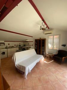 a bedroom with a white bed and a kitchen at Appartement Mugron in Mugron