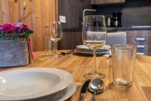 a wooden table with two wine glasses and a plate at Apartments Wimpissinger in Uderns +95 photos