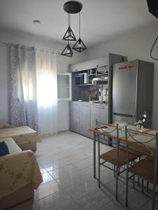 a kitchen and living room with a table and a refrigerator at Elina House 2 in Nikiti