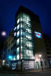 un grand bâtiment avec une horloge la nuit dans l'établissement Cabinn Odense, à Odense