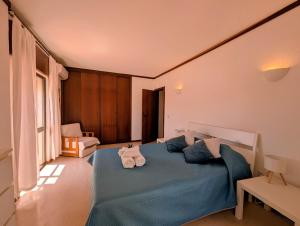 a bedroom with a blue bed with towels on it at 06 Sra da Rocha - Casas & Papeis in Porches +29 photos