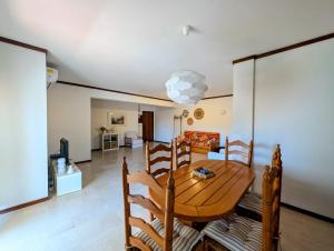 a dining room with a wooden table and a living room at 06 Sra da Rocha - Casas & Papeis in Porches