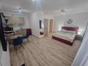 a bedroom with a bed and a table and a kitchen at Apartamenty Centrum Plac Wolności ApartHotel wyjątkowy in Kielce