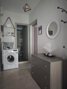 a laundry room with a washing machine and a mirror at Elina House 2 in Nikiti
