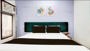 a bedroom with a large bed with a green headboard at Shree Hotel in Rewāri