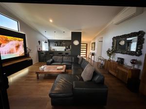 a living room with a couch and a table at Among The Trees Guest Suite in Kooralbyn