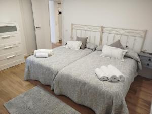 a bedroom with a large bed with towels on it at La casa de Carmen in Neda