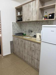a kitchen with wooden cabinets and a white refrigerator at Laila's studio in Haifa