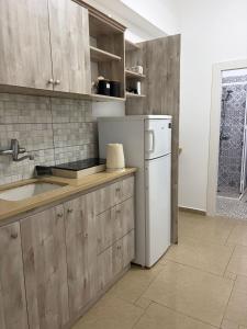 a kitchen with wooden cabinets and a white refrigerator at Laila's studio in Haifa