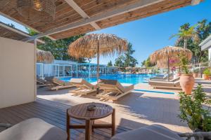 an outdoor patio with chairs and a swimming pool at Bamboo Suites Hotel - Adults Only in Ialysos