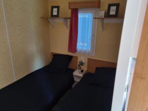 ein kleines Zimmer mit zwei Betten und einem Fenster in der Unterkunft Petit logement tranquille in Wanchy-Capval