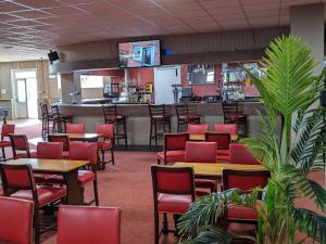 a restaurant with red chairs and tables and a bar at The Lighthouse Chalet in Leysdown-on-Sea