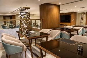 a restaurant with tables and chairs and a television at Seagull Serviced Apartments in Jeddah