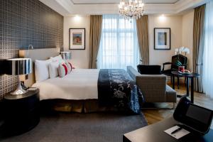 a hotel room with a large bed and a chair at Hotel Schweizerhof Bern & Spa in Bern +46 photos