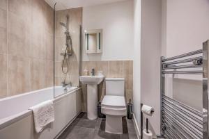 a bathroom with a toilet and a sink and a tub at Stylish Flat in the City Centre - Pass the Keys in Portsmouth +20 photos