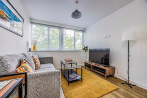 a living room with a couch and a flat screen tv at Stylish Flat in the City Centre - Pass the Keys in Portsmouth