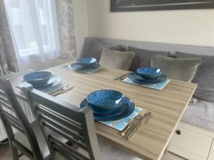 a wooden table with blue bowls and plates on it at Hardy's Hut in Felton +4 photos