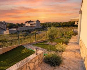 a cat standing on a wall next to a yard at Villa Aurea Luxury Sunset with Pool in Krimovice
