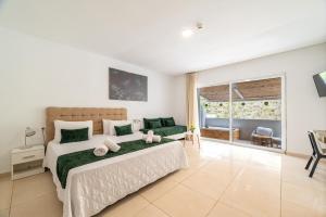 a bedroom with a large bed and a large window at Bamboo Suites Hotel - Adults Only in Ialysos +118 photos