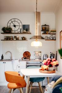 a kitchen with a table and a clock on the wall at Green Gables Bed and Breakfast in Cygnet