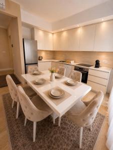 a kitchen with a large white table and chairs at Aria Lux Belgrade Waterfront in Belgrade
