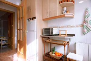 a kitchen with a white refrigerator and a microwave at Iberia TM Apartments Real Villa in Navalcarnero
