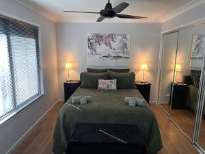 a bedroom with a bed and a ceiling fan at Among The Trees Guest Suite in Kooralbyn