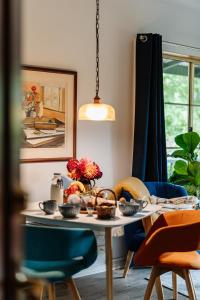 a dining room table with blue chairs and a table with flowers at Green Gables Bed and Breakfast in Cygnet +31 photos
