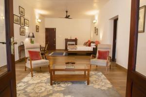 a living room with a couch and a bed at Sinna Dorai's Rotti Kadai Bungalow in Vālpārai