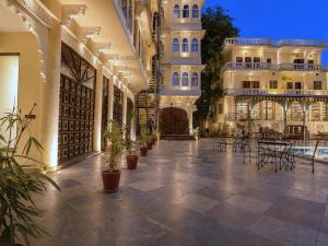 a courtyard of a building with potted plants and tables at The Amar Mahal Luxury Heritage Hotel Near Fateh Sagar Lake, Udaipur in Udaipur