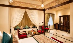 a bedroom with a bed and a living room at The Amar Mahal Luxury Heritage Hotel Near Fateh Sagar Lake, Udaipur in Udaipur