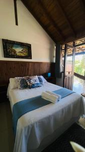 a bedroom with a large white bed with towels on it at Pousada Aurora in Praia do Rosa +95 photos