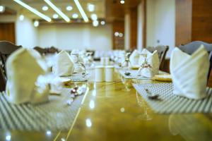 a long table with white napkins and glasses on it at The Amar Mahal Luxury Heritage Hotel Near Fateh Sagar Lake, Udaipur in Udaipur