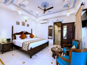 a bedroom with a bed and a table and chairs at The Amar Mahal Luxury Heritage Hotel Near Fateh Sagar Lake, Udaipur in Udaipur +60 photos