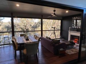 a living room with a table and a fireplace at Among The Trees Guest Suite in Kooralbyn