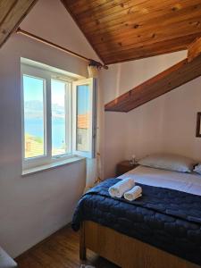 a bedroom with a bed and a large window at Apartmani Banić Apartman 4 in Postira