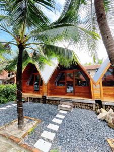 a house with a palm tree in front of it at Waikiki Lagi Beach in Ấp Tam Tân