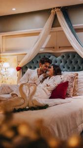 a man and a woman laying in a bed at Le Boutique Hotel Gramado - Exclusivo para Casais in Gramado