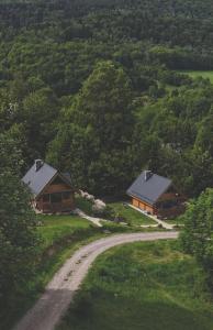two cottages on a hill with a dirt road at Tu W Dolinie in Ropica Górna